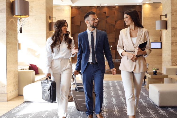 Business travelers walking through a hotel guided by staff